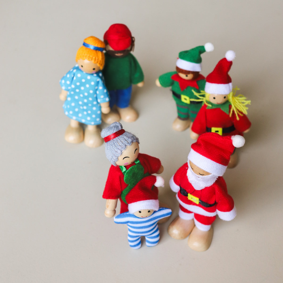 Bendy elf doll with its arm bent into a wave, showing the flexible limbs and wooden hands and feet.