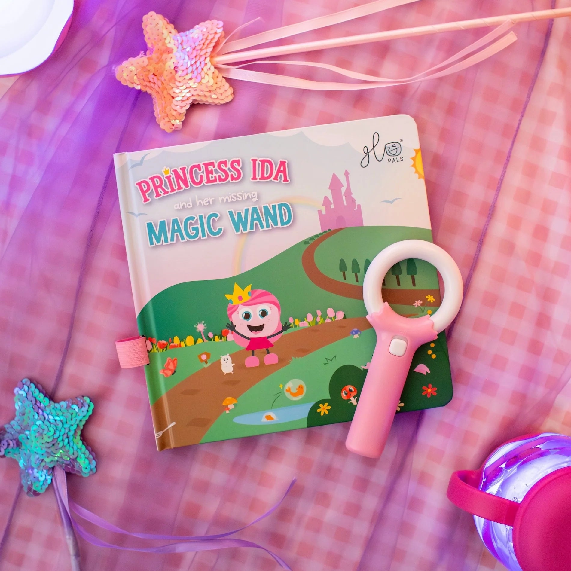 Princess themed magic wand and book on a checkered fabric background