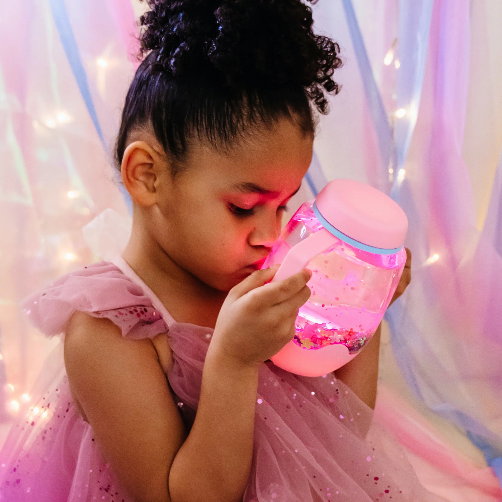 Glo Pals sensory play jar glowing in water