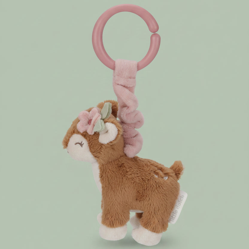 Plush deer toy with pink rattle on a white background