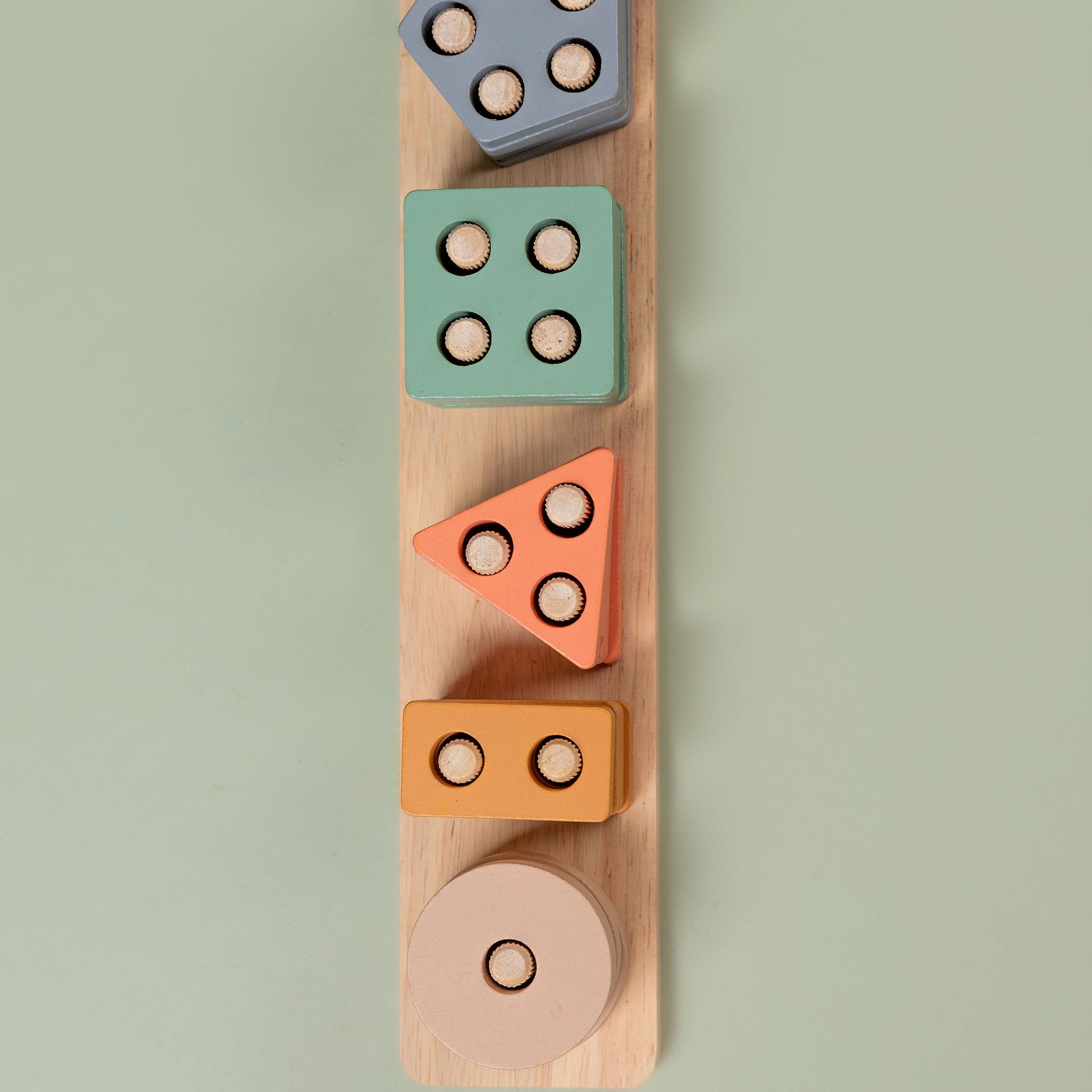 Pastel wooden geometric shape sorter with vertical rods and colourful stacked shapes