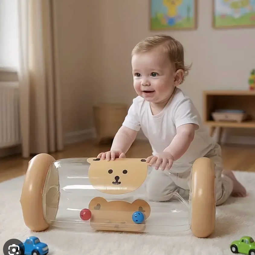 A baby in a white onesie kneels on a white rug playing with a transparent plastic bear-shaped toy walker with tan wheels in a softly lit nursery.