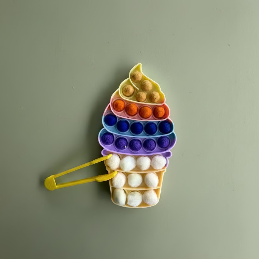 A colourful ice cream cone-shaped pop-it toy with a yellow handle, featuring rows of colorful bubbles on a light blue background.