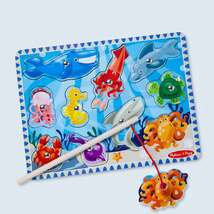 Colorful fishing game with sea creature pegs on a blue mat, featuring Melissa & Doug branding.