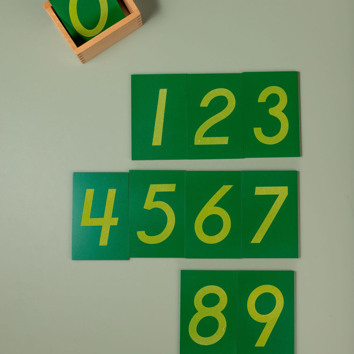 The full set of ten numeral boards stacked inside the wooden storage box to show the compact, tidy set size.