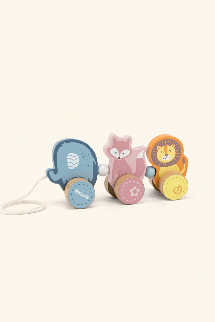 A wooden toy train set with three animal characters: a blue polar bear, a pink fox, and an orange lion, each with a round wooden wheel. The toy is photographed on a clean white background.