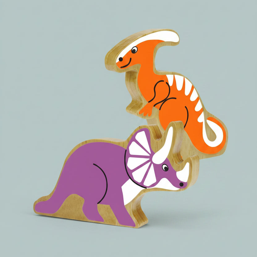 Two wooden dinosaur toy blocks stacked on top of each other, featuring an orange parathereinosaur on top and a purple triceratops below, both with natural wood edges.
