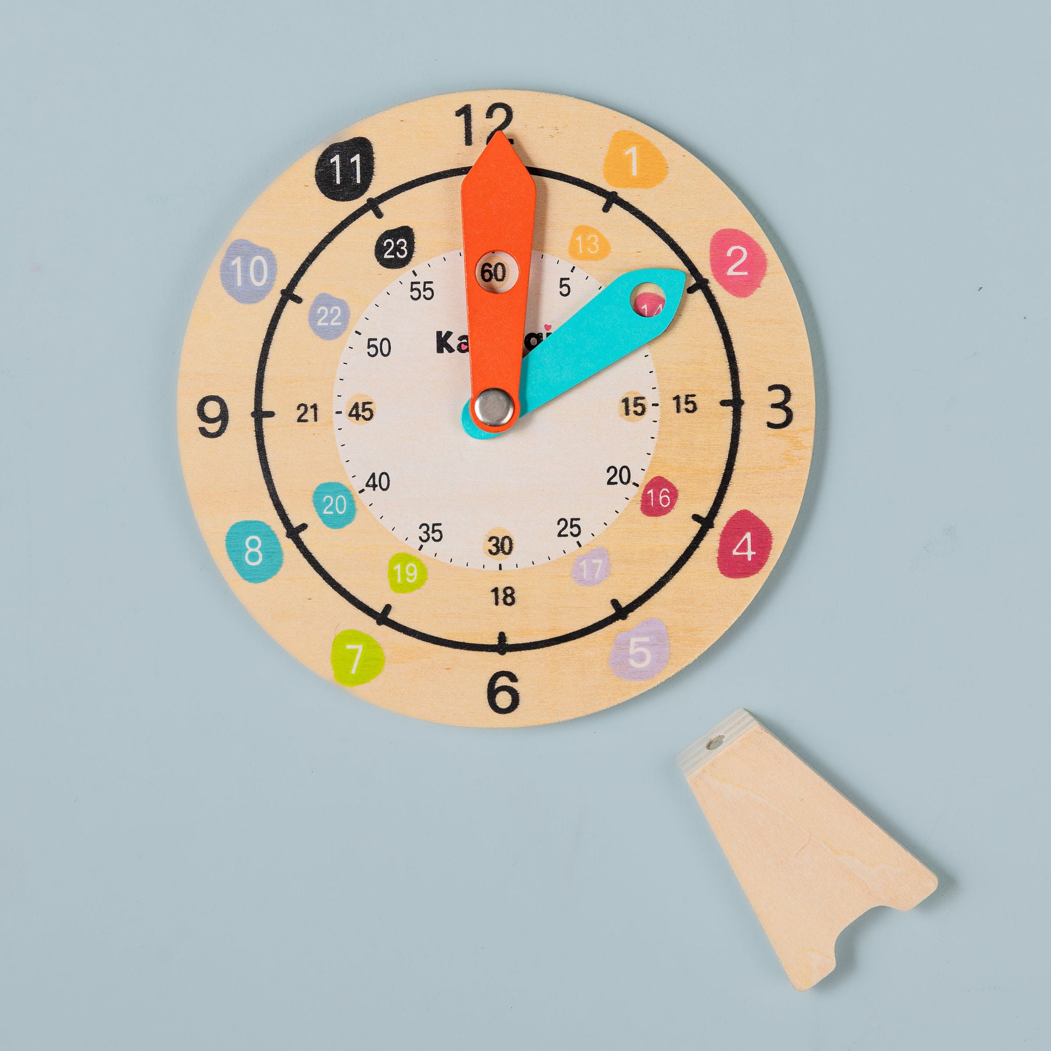 Wooden teaching clock sitting in magnetic stand — hands-on analogue time learning tool for home and classroom use
