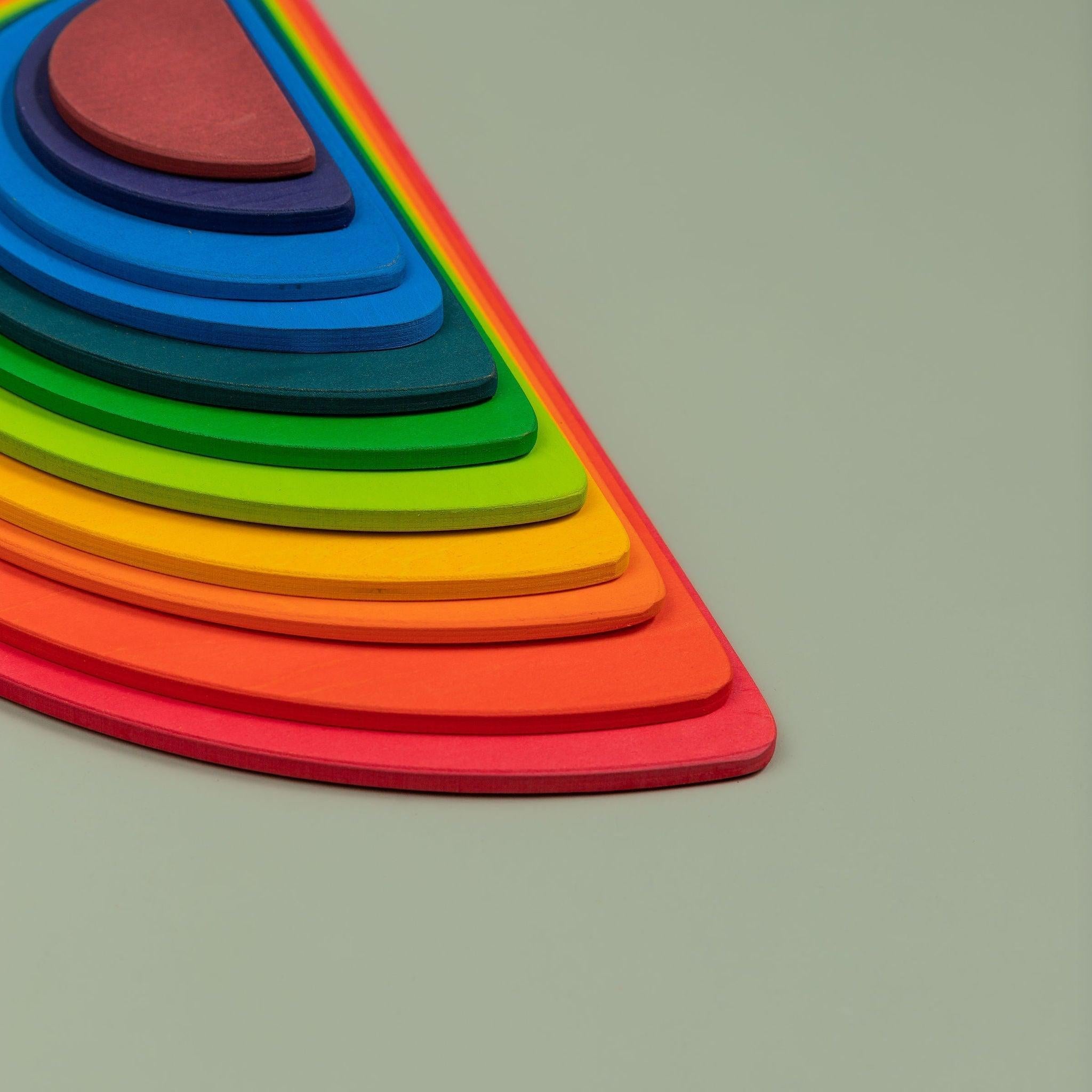 Close-up of smooth non-toxic painted wooden rainbow stacker pieces showing texture and colour detail