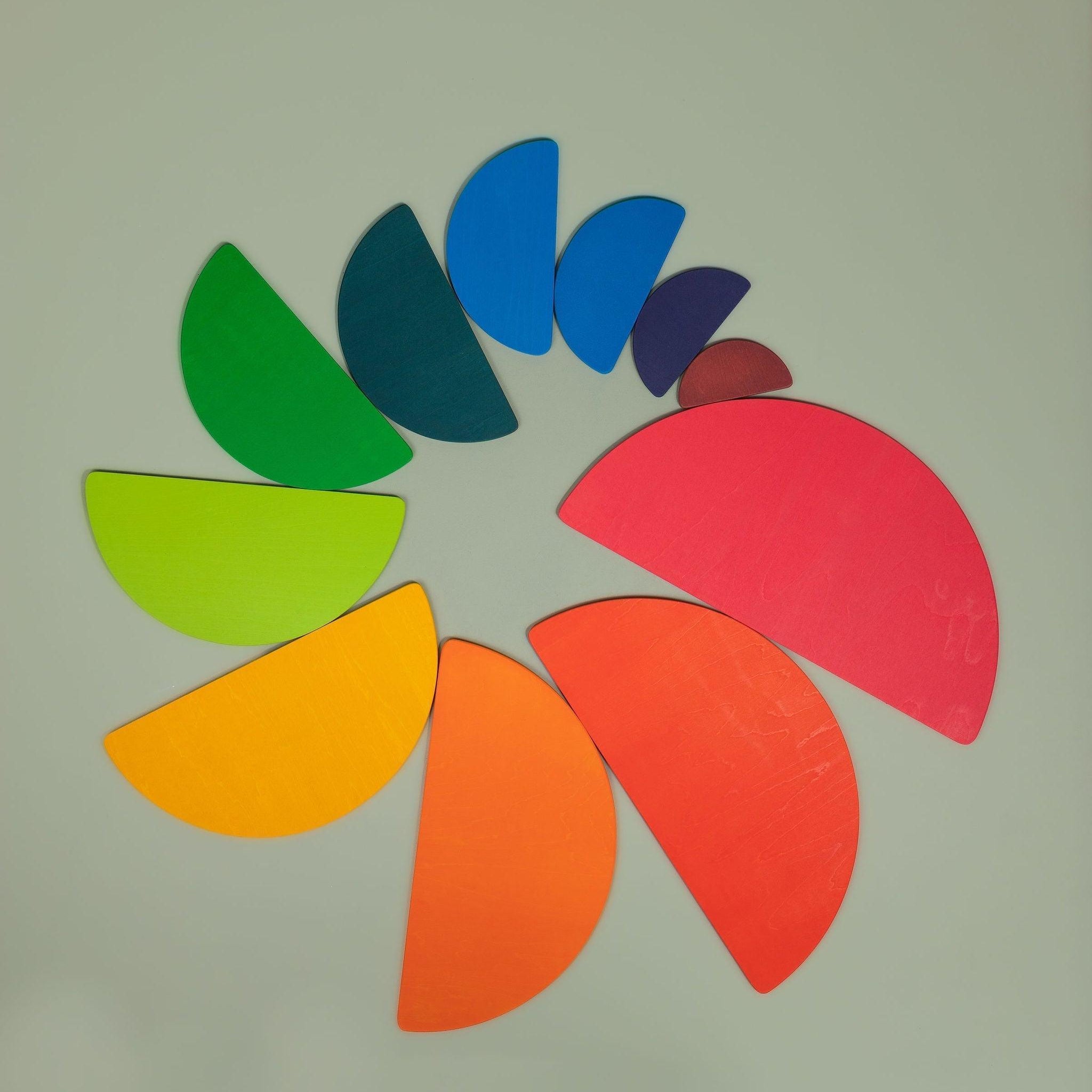 Semi-circle wooden pieces from the rainbow stacker set arranged in a nesting pattern