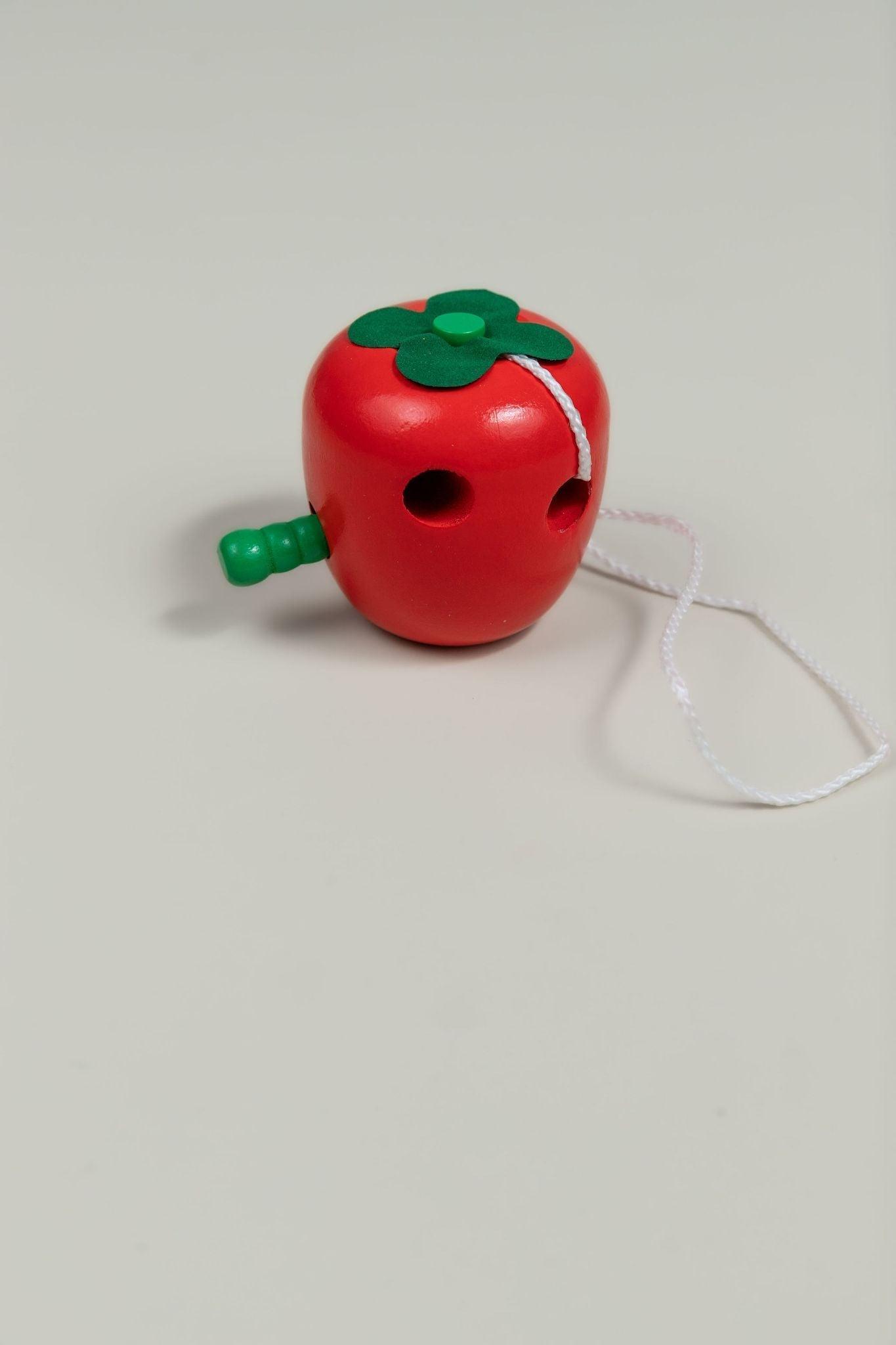 Wooden apple worm toy showing worm threading through hole - fine motor and hand-eye coordination toy for babies