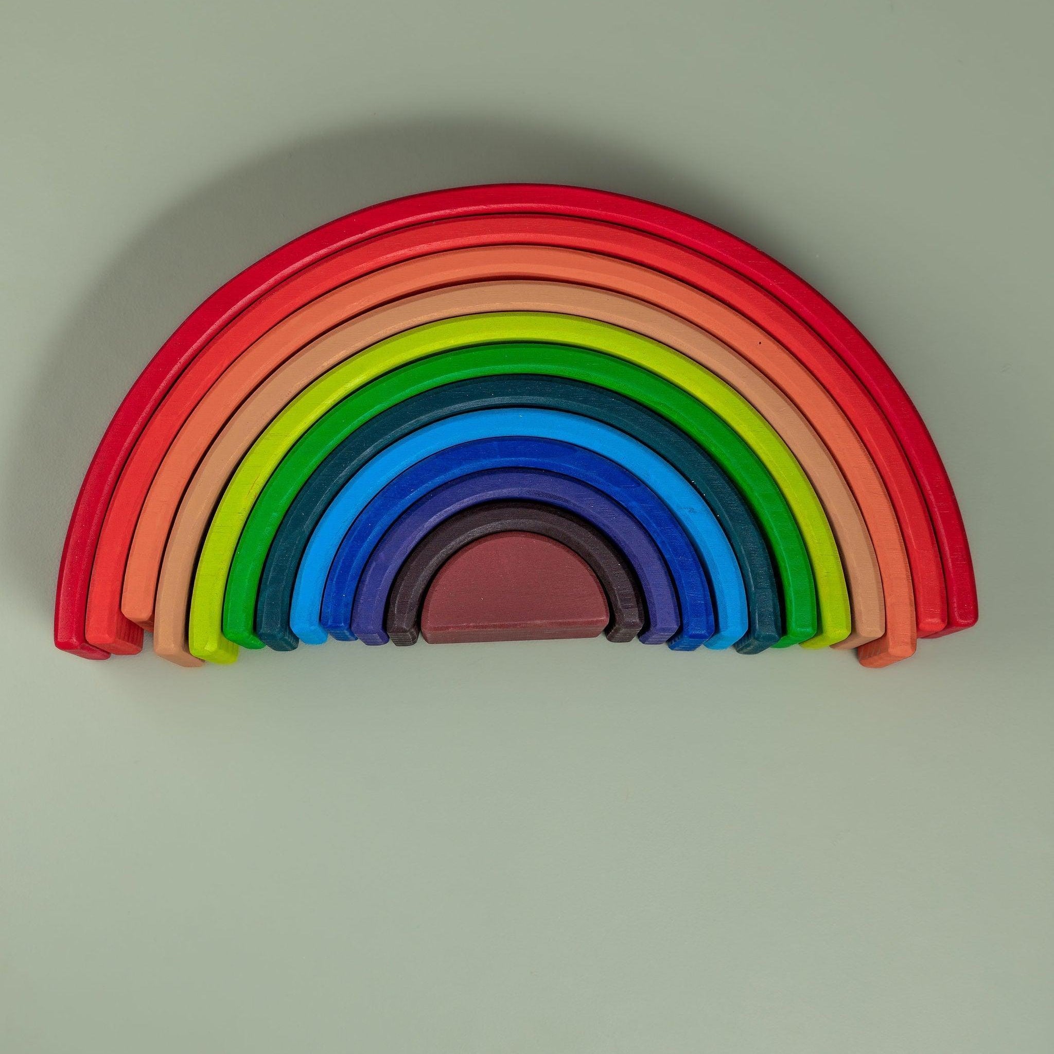 Rainbow stacker arches stacked in size order showing graduated sequence — Montessori size sorting toy