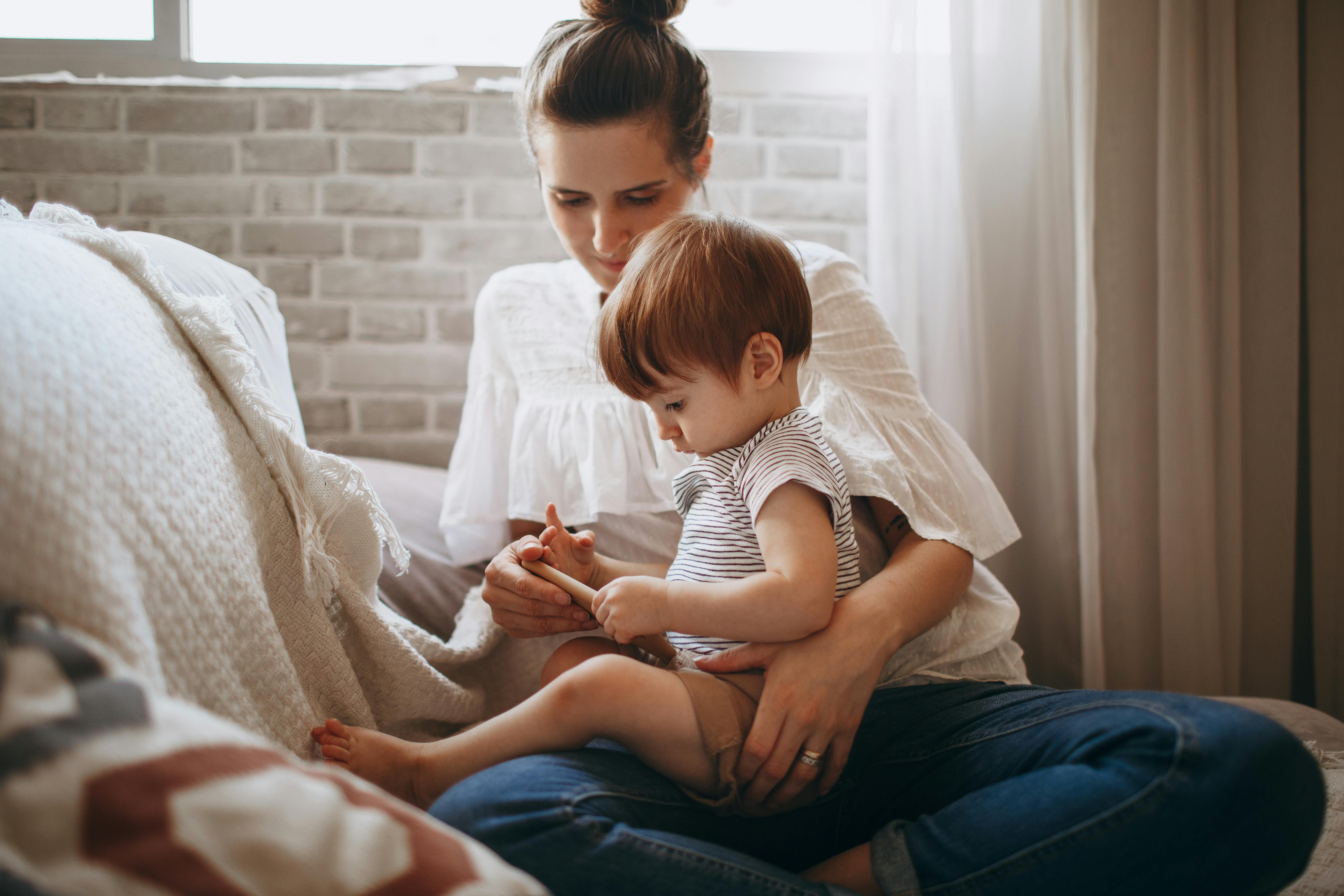 Parent calmly comforting distressed toddler on lap.