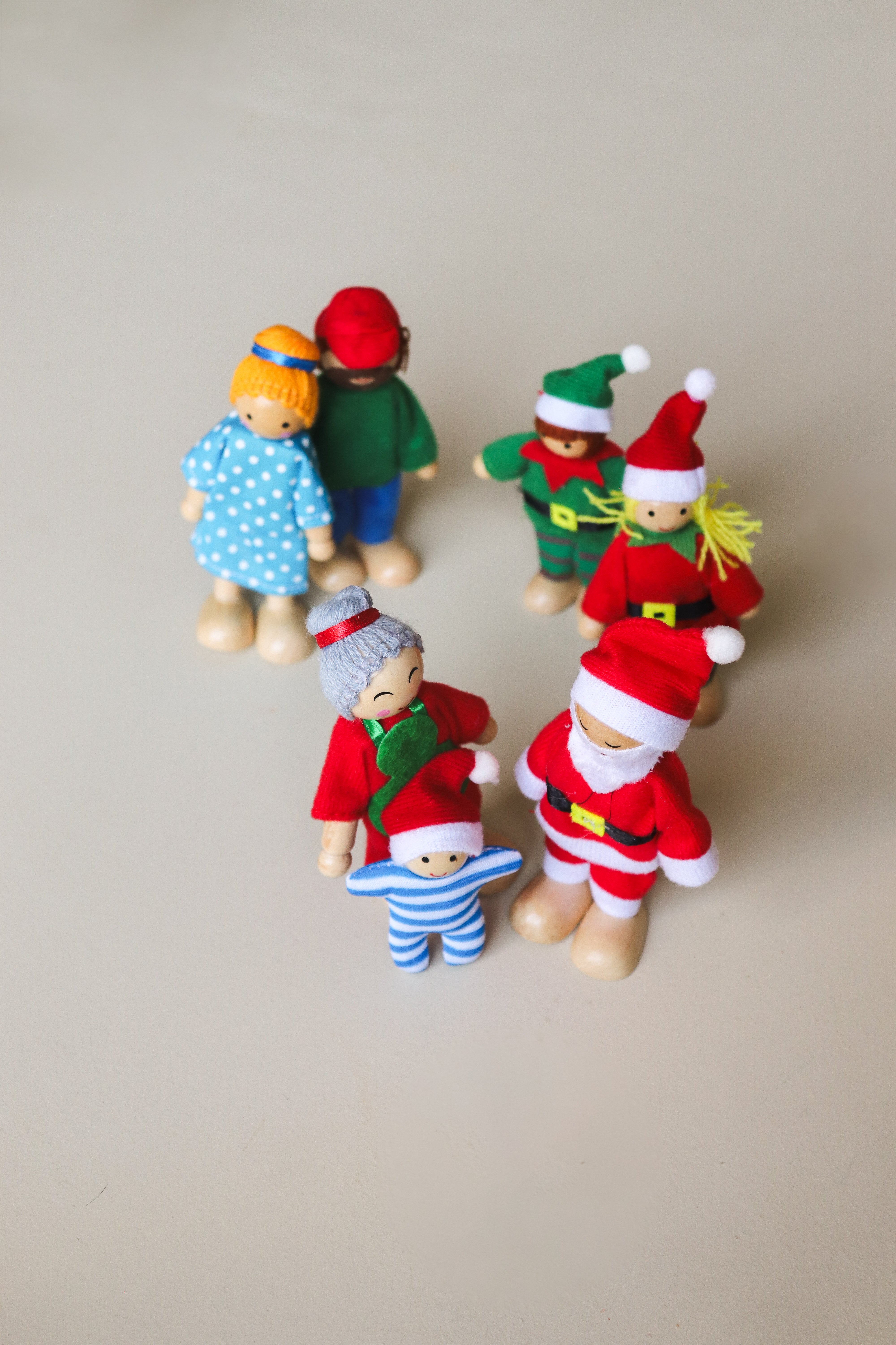 Bendy elf doll with its arm bent into a wave, showing the flexible limbs and wooden hands and feet.