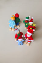 Bendy elf doll with its arm bent into a wave, showing the flexible limbs and wooden hands and feet.