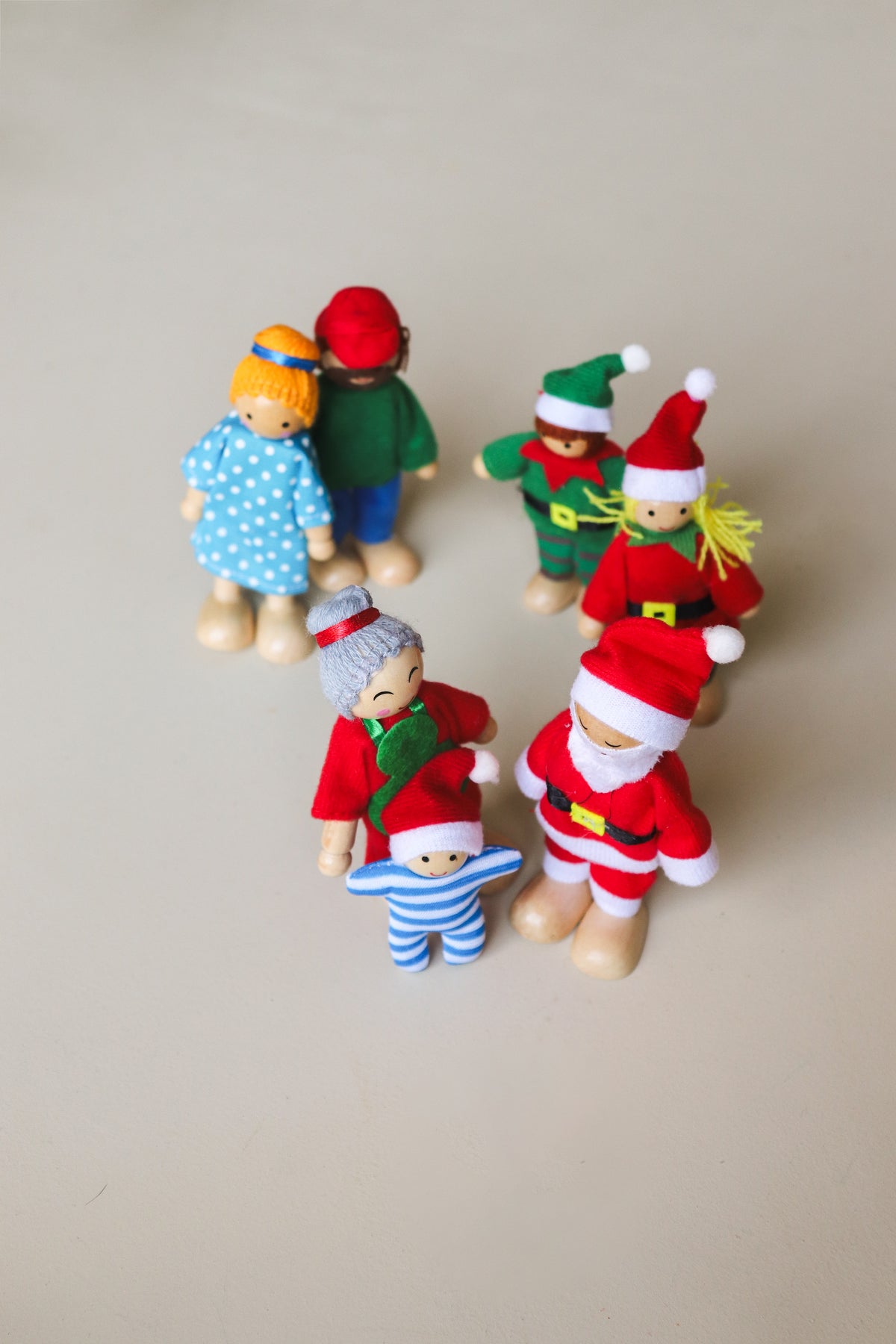 Bendy elf doll with its arm bent into a wave, showing the flexible limbs and wooden hands and feet.