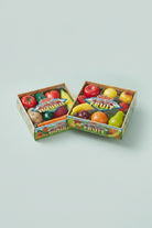 Two boxes of toy fruits and vegetables with colorful packaging on a white background.