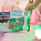 Children's book titled 'Princess Ida and her magical light-up magic wand' with a toy light-up wand on a checkered surface.