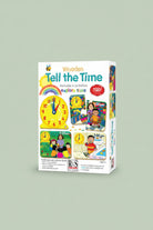 Front and side views of the 'Tell the Time' educational toy box by RGS Group, featuring colorful cartoon illustrations of clocks, children, and activities on a white background.