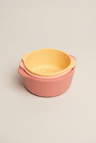 Two-toned pink and yellow plastic container on a white background