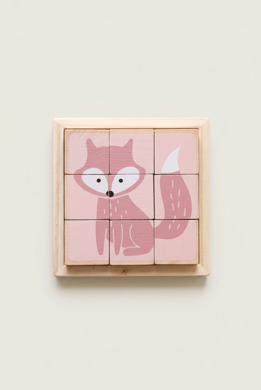 A set of six-sided wooden puzzle blocks with a pink background and a fox illustration on each block, placed on a wooden tray.