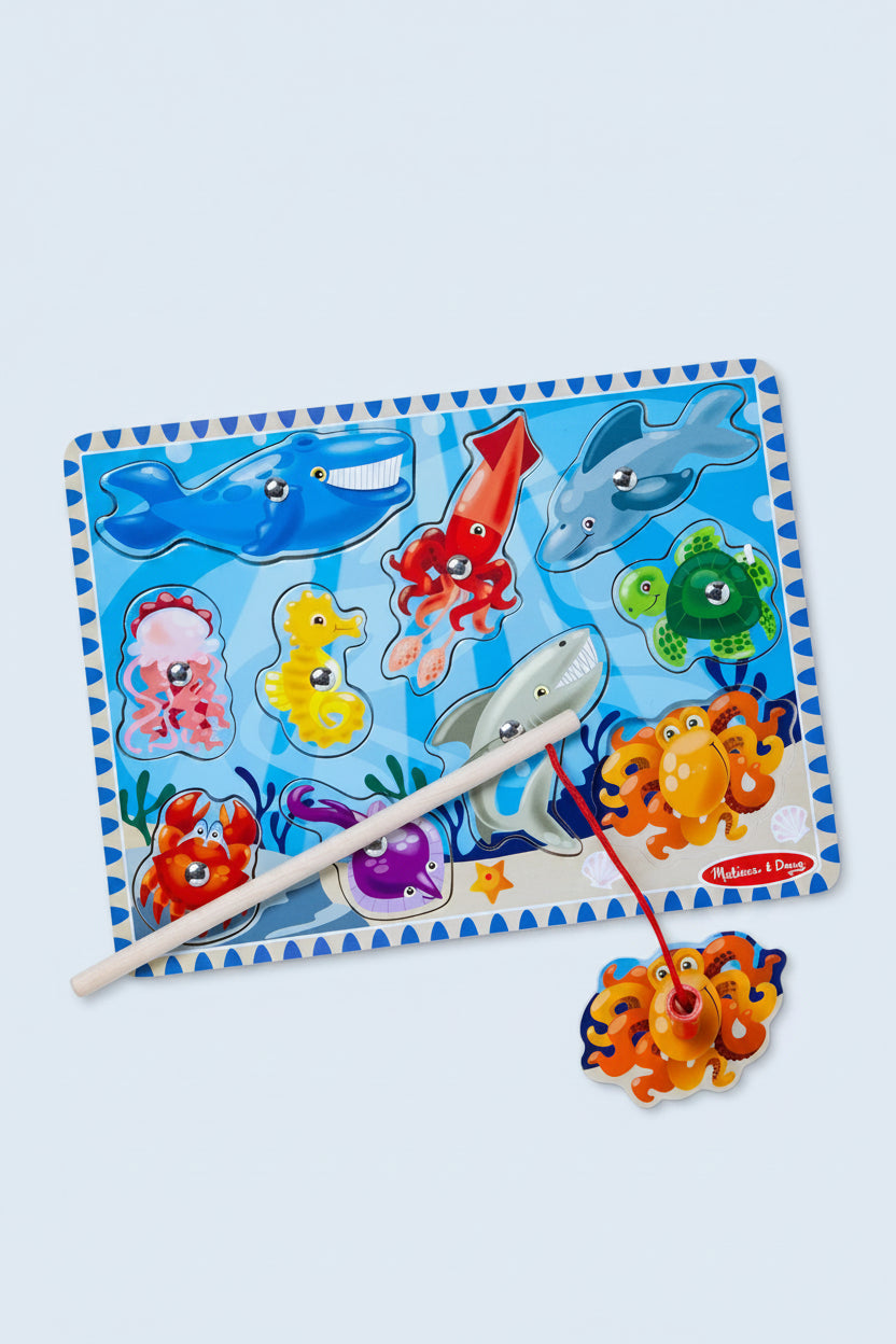 Colorful fishing game with sea creature pegs on a blue mat, featuring Melissa & Doug branding.