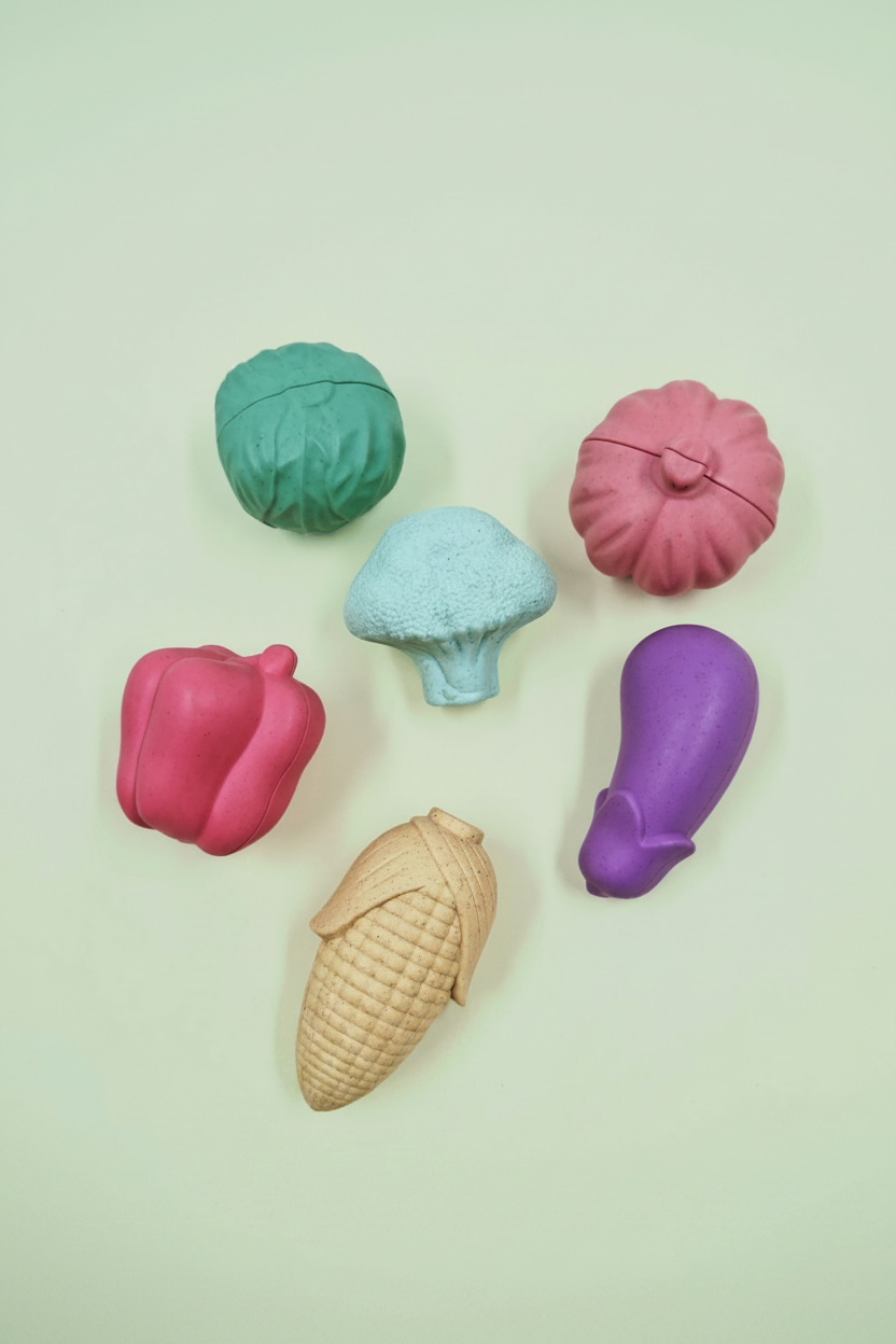 Colorful plastic   vegetable-shaped containers on a light background