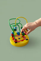 Colorful lion-shaped bead maze toy on a wooden surface