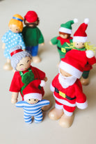Close-up of the Santa and Mrs Claus bendy dolls showing their painted wooden faces, felt outfits and Santa’s yellow belt buckle.