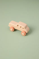 Small pink silicone  car on a light green background
