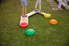 Set of colourful rainbow stepping stones arranged on a wooden floor for children's balance play