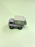Toy garbage truck with recycling symbol on a light green background