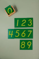The full set of ten numeral boards stacked inside the wooden storage box to show the compact, tidy set size.