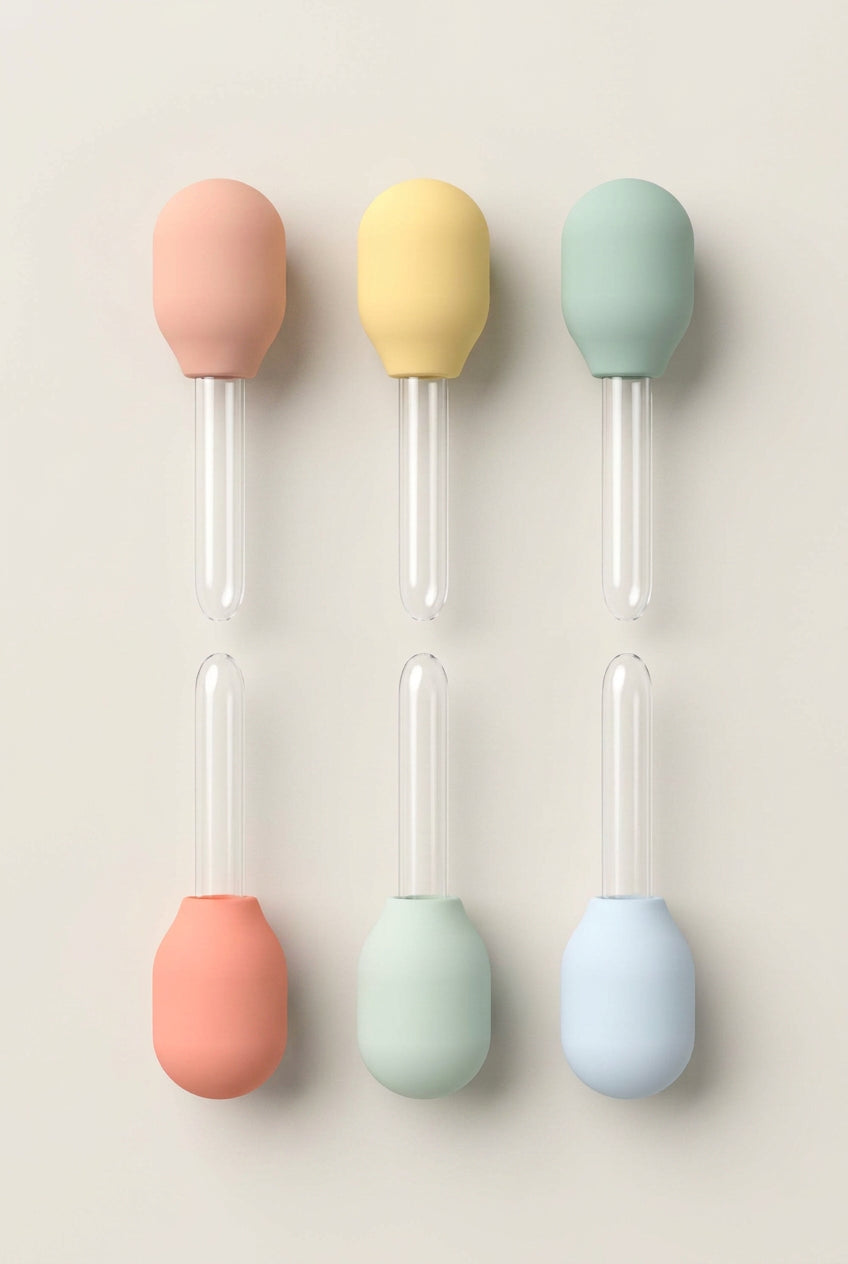 Set of six colorful silicone droppers on a white background