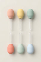 Set of six colorful silicone droppers on a white background