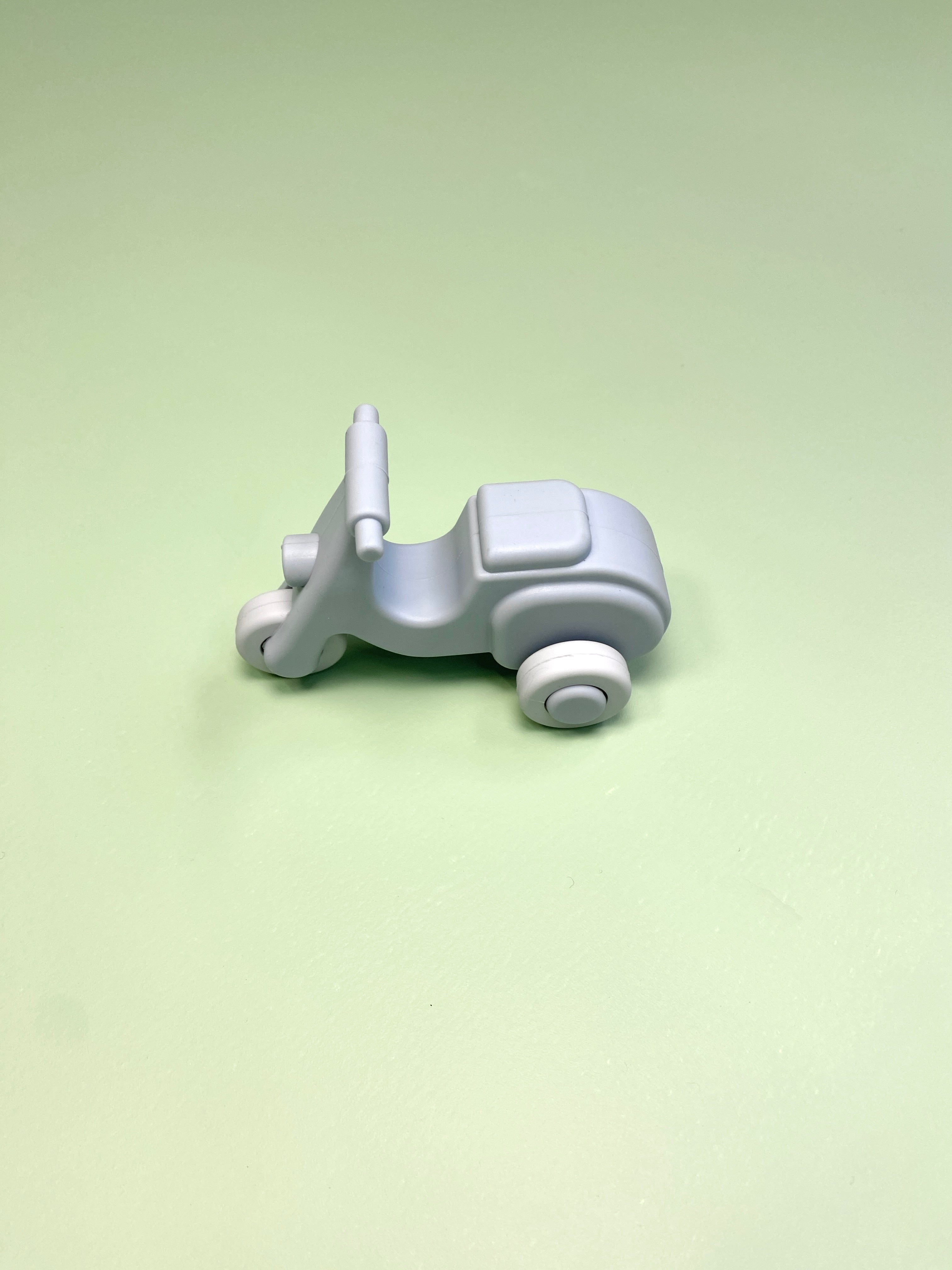 Small blue  silicone  vespa  on a light green background