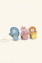 A wooden toy train set with three animal characters: a blue polar bear, a pink fox, and an orange lion, each with a round wooden wheel. The toy is photographed on a clean white background.