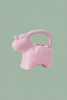 A light pink watering can shaped like a winged unicorn with a carrying handle, shown on a plain white background.