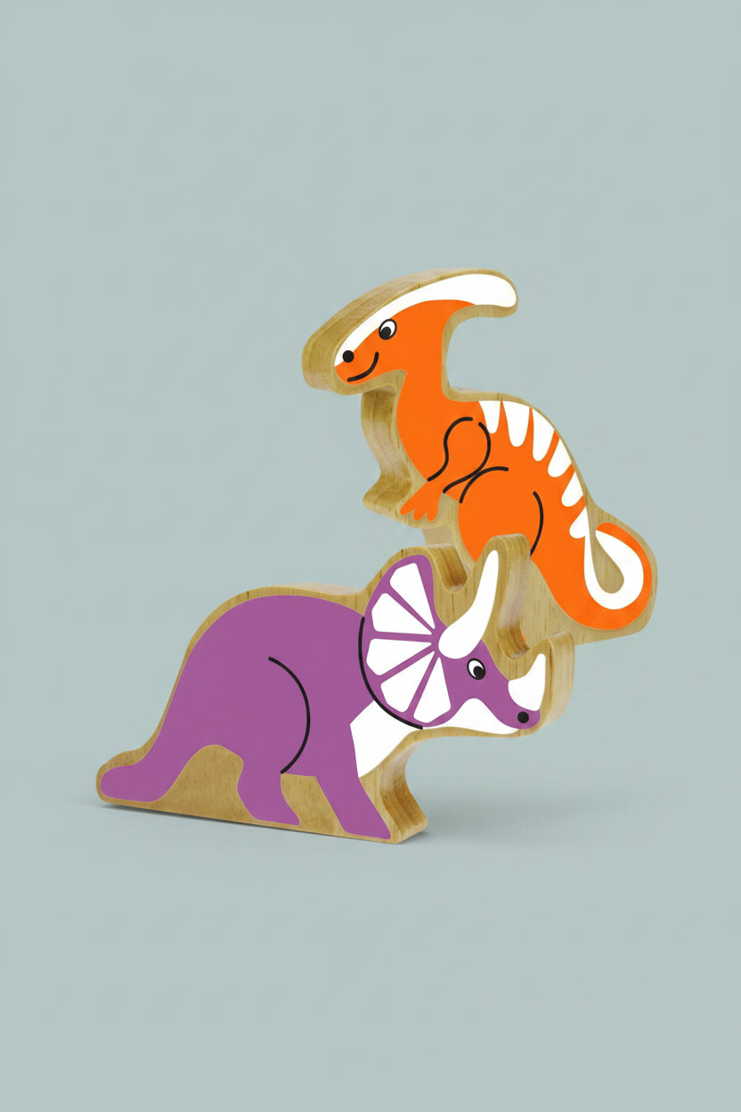 Two wooden dinosaur toy blocks stacked on top of each other, featuring an orange parathereinosaur on top and a purple triceratops below, both with natural wood edges.
