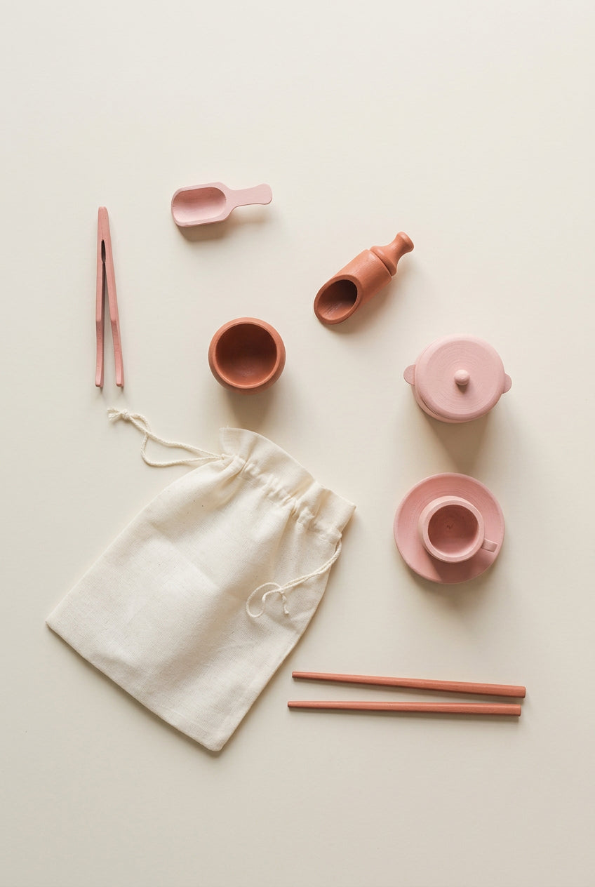 Wooden sensory tool set with lidded pot, cup, plate, bowl, two scoops, tweezers and two sticks arranged on a white background – Tiny Tree Toys South Africa