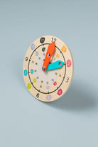 Wooden teaching clock with movable hour and minute hands on white background — analogue time learning toy for kids