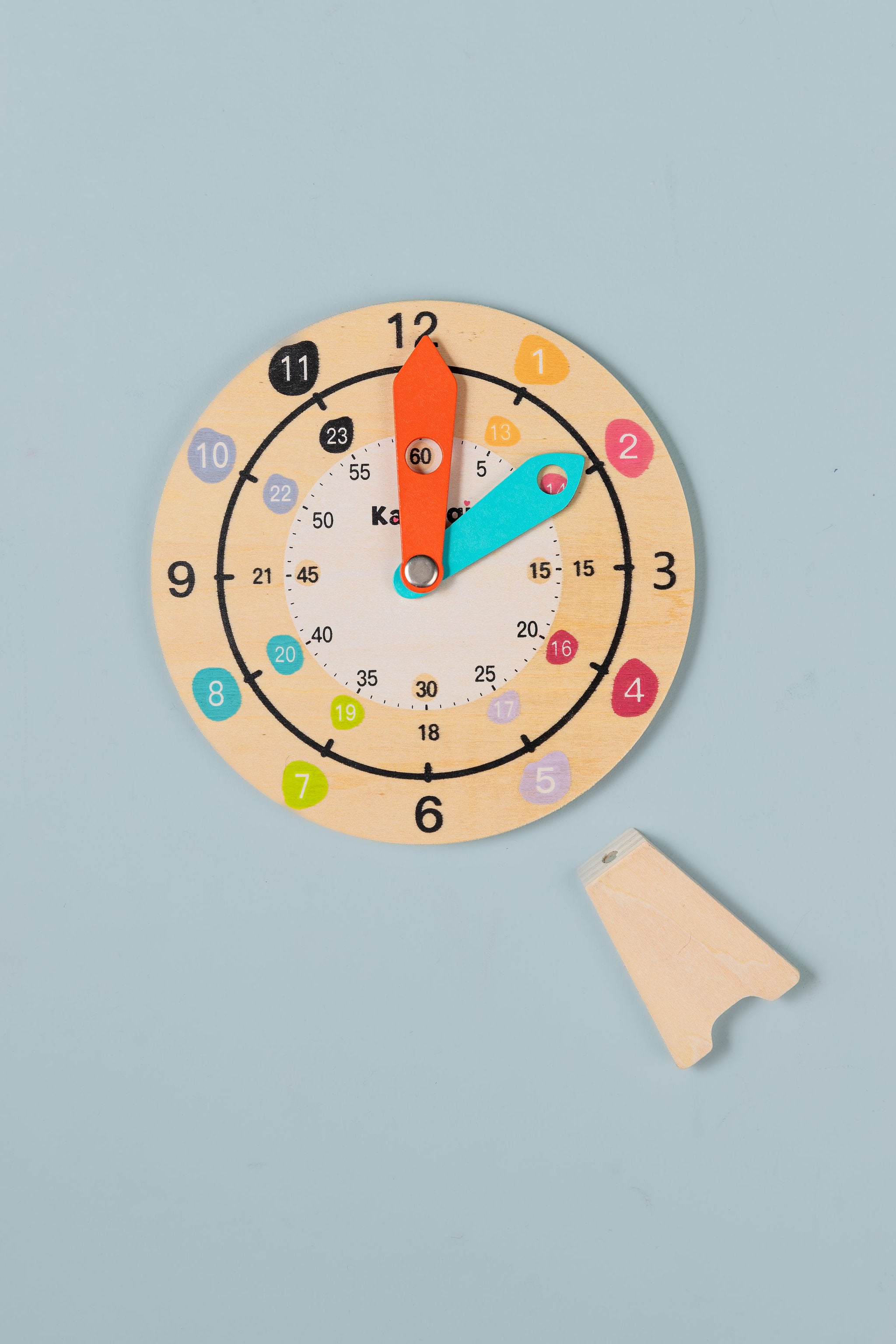 Wooden teaching clock sitting in magnetic stand — hands-on analogue time learning tool for home and classroom use