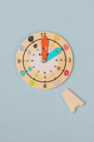 Wooden teaching clock sitting in magnetic stand — hands-on analogue time learning tool for home and classroom use
