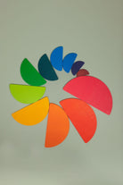 Semi-circle wooden pieces from the rainbow stacker set arranged in a nesting pattern